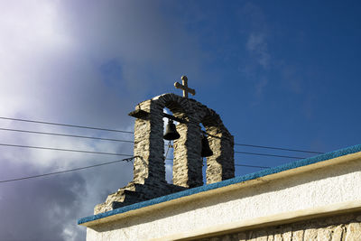 Low angle view of birds on statue against sky