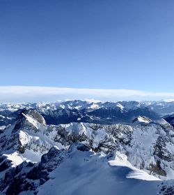 Scenic view of snowcapped mountains against clear blue sky