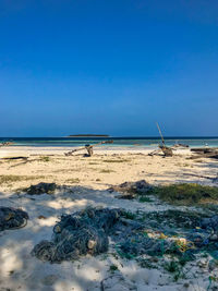 Scenic view of beach against clear blue sky