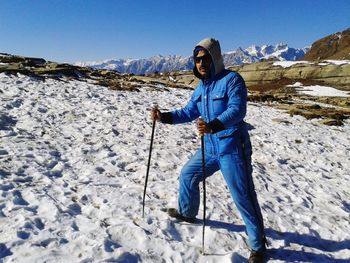 Full length of man standing on snowcapped mountain