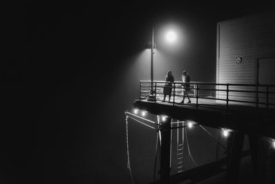 People standing in illuminated staircase at night