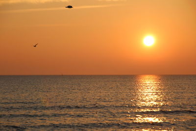 Scenic view of sea against orange sky