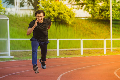 Full length of young man running on track