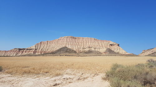 Rock formations in desert against clear blue sky