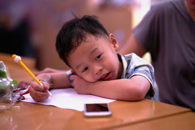 Close-up of boy writing on paper