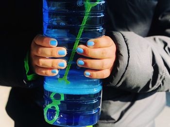 Close-up of hands holding glass bottle