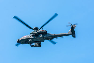 Low angle view of airplane flying against clear blue sky