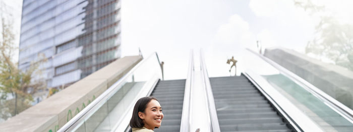 Low angle view of woman standing in city