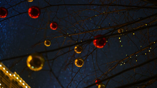 Low angle view of illuminated lanterns against sky at night