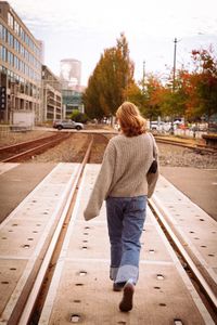 Rear view of woman walking on road