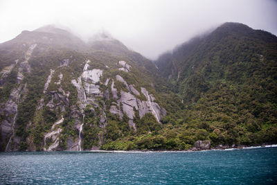 Scenic view of sea and mountains against sky