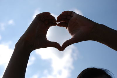 Low angle view of heart shape against sky