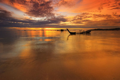 Scenic view of sea against dramatic sky during sunset