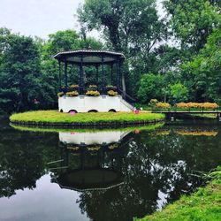 Gazebo by lake against sky