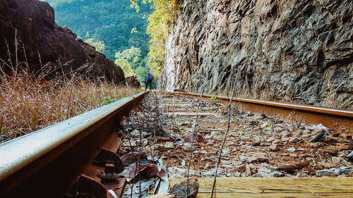 Woman on railroad track amidst mountains