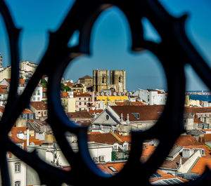 Cityscape against clear sky seen through railing in city