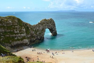 High angle view of durdle door, tourists on beach, summer, england, dorset