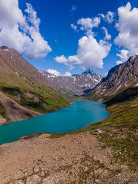 Scenic view of lake by mountains against sky