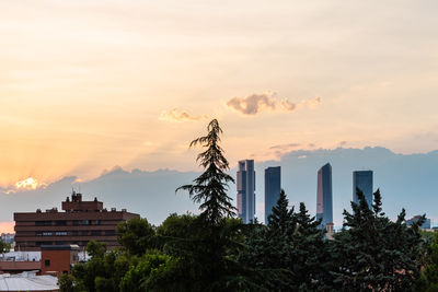 View of cuatro torres financial district against sky at sunset