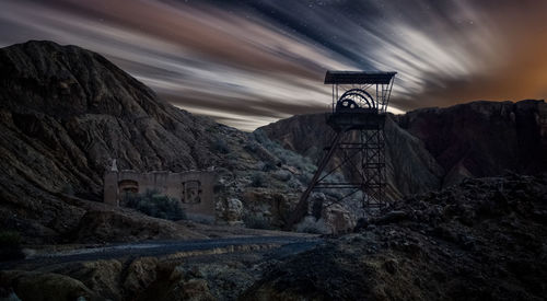 Scenic view of building and mountains against sky at dusk