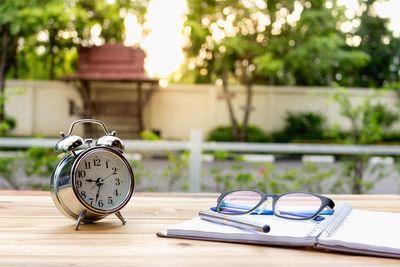 Close-up of alarm clock and eyeglasses on table