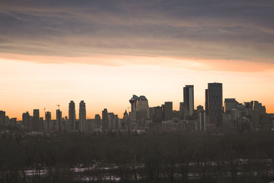 Modern buildings against sky during sunset