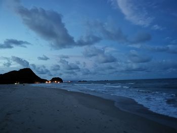 Scenic view of beach against sky at sunset