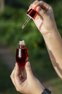 Cropped hand of woman holding bottle