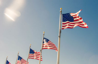 Low angle view of flag against blue sky