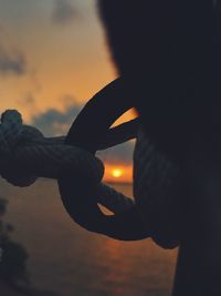 Close-up of silhouette hand against sky during sunset