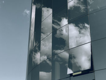 Low angle view of glass building against sky