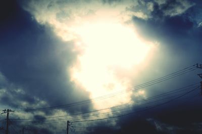 Low angle view of silhouette electricity pylon against sky