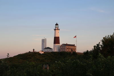 Montauk point lighthouse on hill against sky during sunset