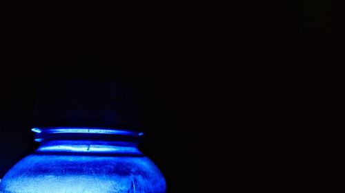 Close-up of illuminated lamp over black background