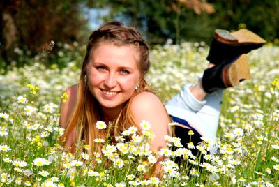 Portrait of smiling woman with flowers on plants