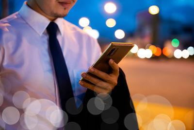 Midsection of businessman using mobile phone