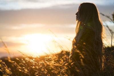 Young woman in nature at sunset