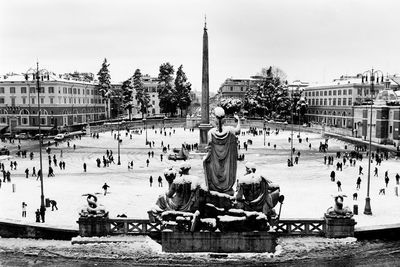 View of statues in city against sky