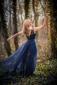 Rear view of female model posing in forest