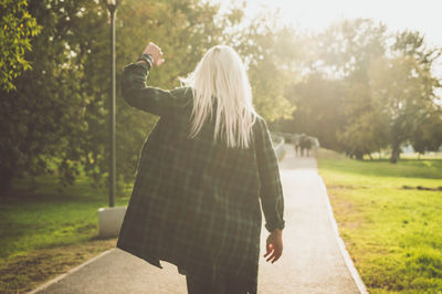 Rear view of woman with umbrella in background