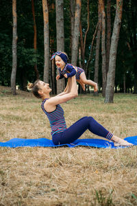 Mom and baby yoga outdoor. wellness, family yoga class, practicing mindfulness and meditation, 