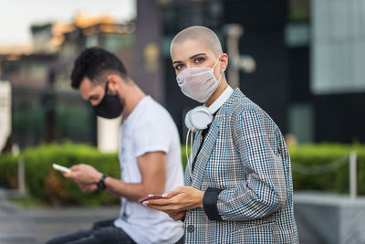 Full length portrait of young man standing on mobile phone