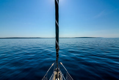 Close-up of boat in sea against clear blue sky