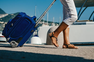 Low angle view of tourist woman with travel bag walking