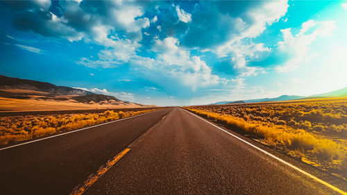 Empty road along countryside landscape