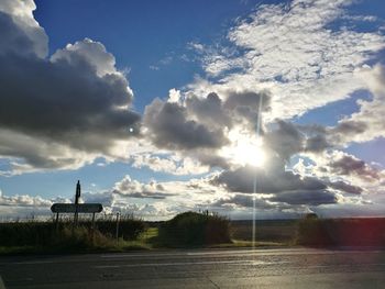 Scenic view of field against cloudy sky