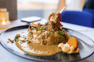 Close-up of tasty gourmet dinner served in plate on dining table at restaurant