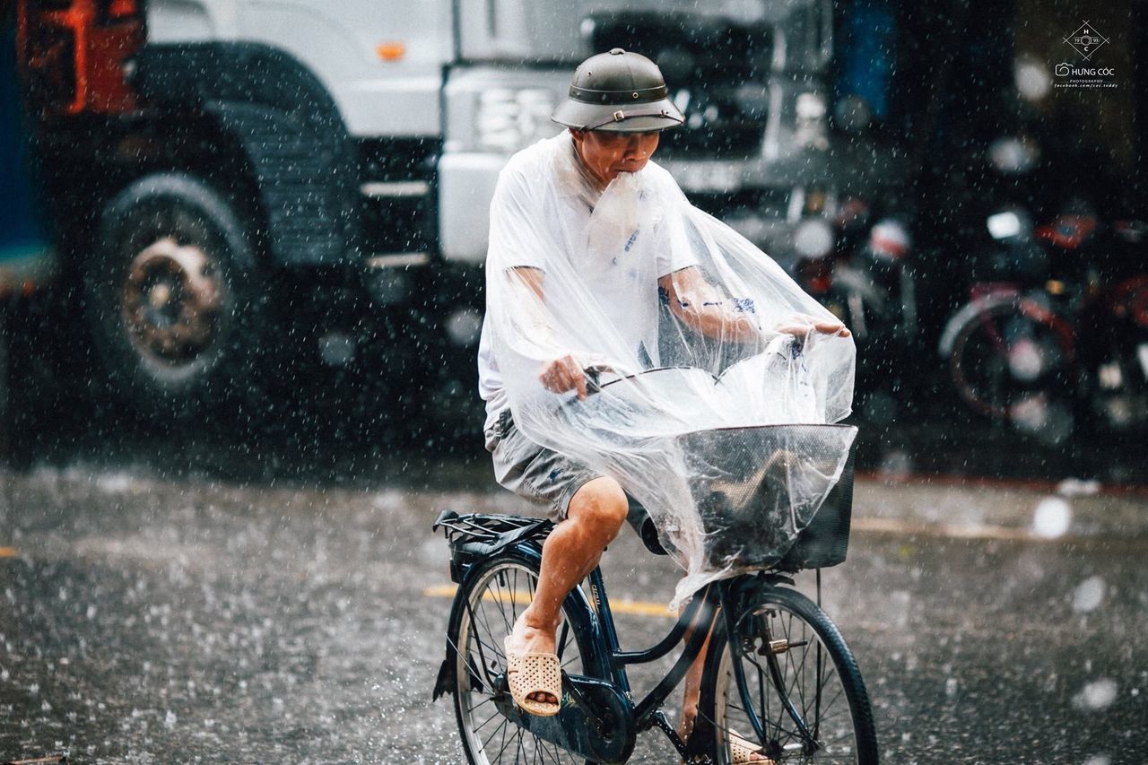 FULL LENGTH OF A MAN RIDING BICYCLE ON ROAD