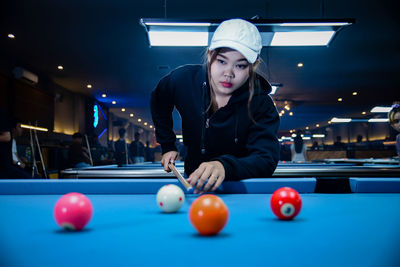 Midsection of man playing pool