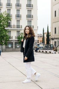 Full length portrait of woman standing in city